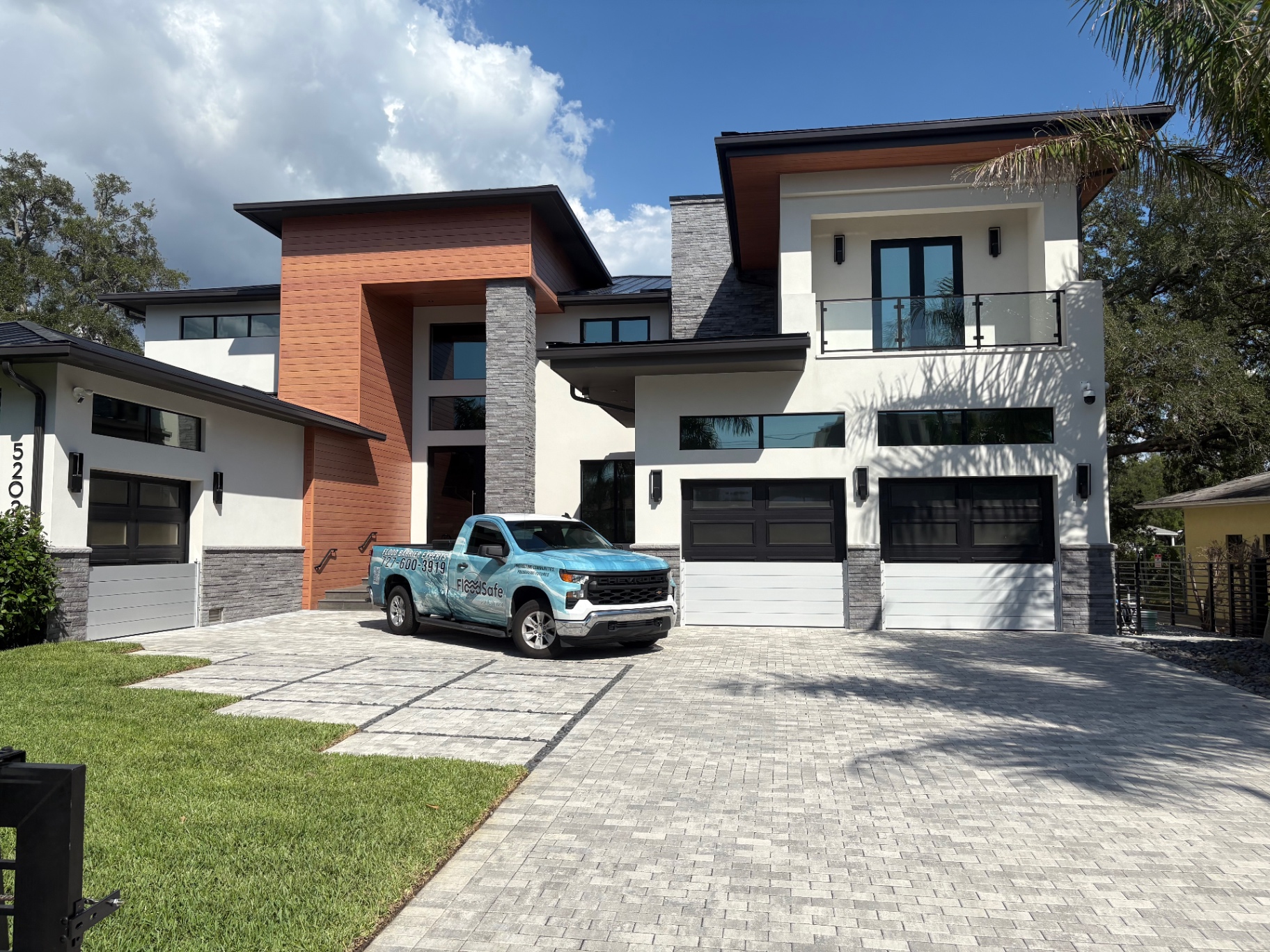 Flood Safe Solution service truck parked at a modern Tampa Bay home with installed flood barriers